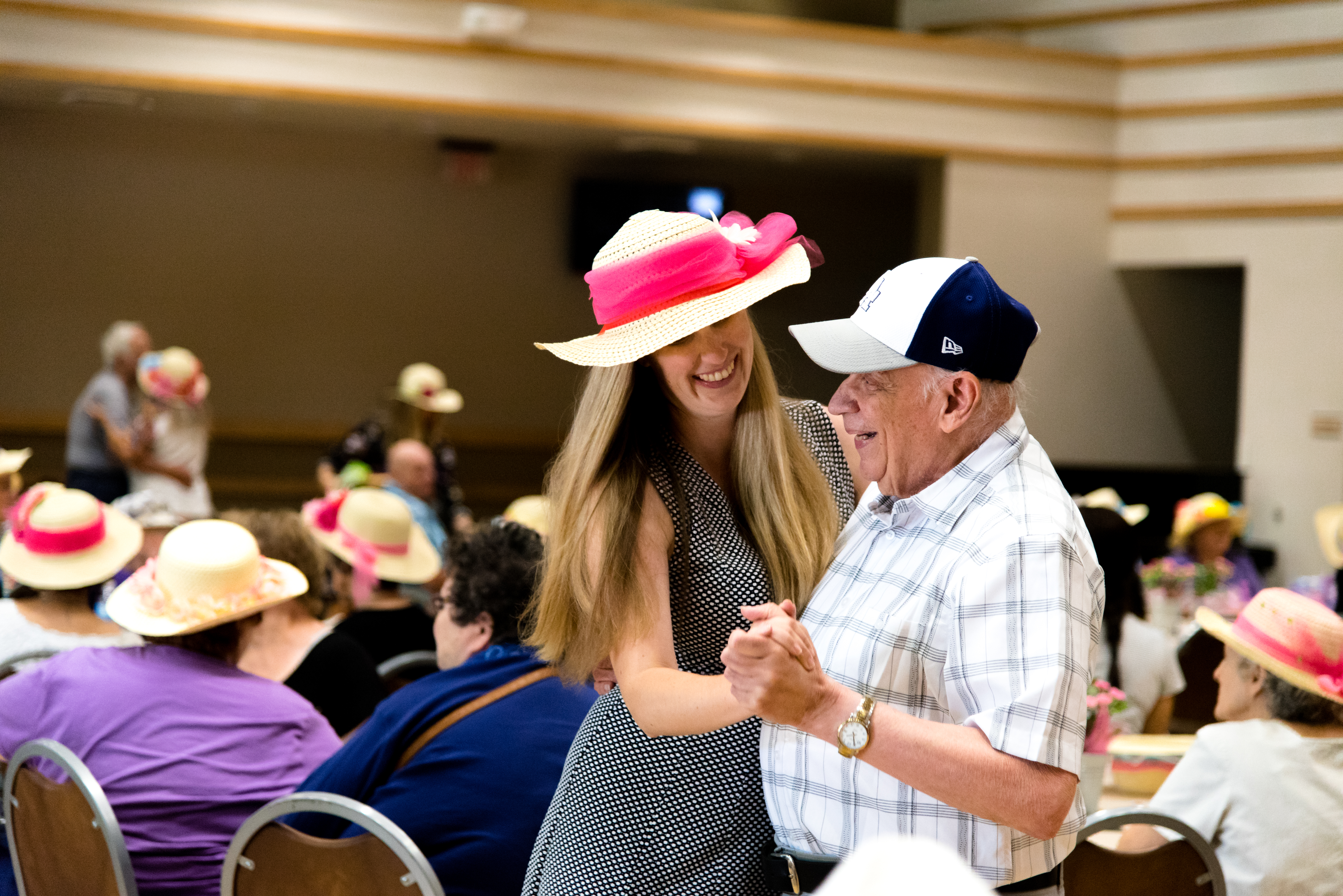 An elderly man and a middle age women dance